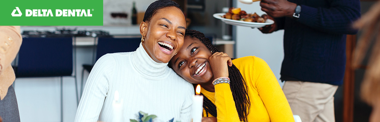 A mother and daughter laughing and smiling at each other. 